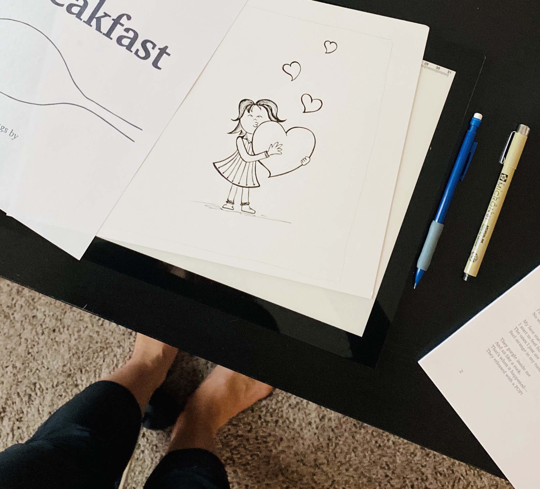 Child hugging large heart illustration for Poems for Breakfast children's book, with drawing tools and book pages on black and beige background, showcasing creative design process